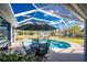 Beautiful pool area with screen enclosure, outdoor seating and landscaping at 1052 Eppinger Dr, Port Charlotte, FL 33953