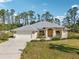 Charming single-story home with a two-car garage, arched entryway, and professionally landscaped front yard at 3896 Slayton Ave, North Port, FL 34286