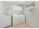 Tiled laundry room features a sink and lots of cabinet space at 3896 Slayton Ave, North Port, FL 34286
