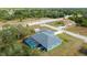 A beautiful aerial view of a light-blue single Gathering home with a screened in pool and shed in the backyard at 9 Logan St, Port Charlotte, FL 33954