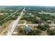 An attractive aerial view of a single Gathering home, surrounded by lush trees and a road nearby at 9 Logan St, Port Charlotte, FL 33954