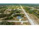 A lush aerial view of a single Gathering home sitting on a quiet road with a canal nearby at 9 Logan St, Port Charlotte, FL 33954
