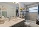 Well-lit bathroom with modern fixtures, gray tile, and ample storage space at 9 Logan St, Port Charlotte, FL 33954