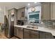 Well-equipped kitchen featuring modern appliances, ample counter space, and stylish gray cabinets, perfect for cooking at 9 Logan St, Port Charlotte, FL 33954