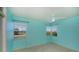 Bright bedroom with aqua-colored walls, tile flooring, and a ceiling fan at 125 Ott Cir, Port Charlotte, FL 33952