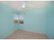 Bright bedroom with aqua-colored walls, tile flooring, and a ceiling fan at 125 Ott Cir, Port Charlotte, FL 33952