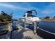 Waterfront home featuring a private boat lift for easy water access and enjoyment with classic dock construction at 125 Ott Cir, Port Charlotte, FL 33952