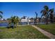 Beautiful waterfront property featuring a private boat dock, lift, lush lawn, and serene canal views at 125 Ott Cir, Port Charlotte, FL 33952