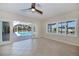 Bright living area with tile floors, fan, and sliding doors to the pool and dock views at 125 Ott Cir, Port Charlotte, FL 33952