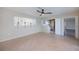 Open-concept living room featuring tile floors, fan, and a view into the kitchen at 125 Ott Cir, Port Charlotte, FL 33952