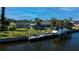 Scenic waterfront property with private boat lift, lush greenery, and backyard pool at 125 Ott Cir, Port Charlotte, FL 33952