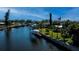 Canal-front house with private boat lift, grassy lawn, mature palm trees, and water views at 125 Ott Cir, Port Charlotte, FL 33952