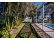 Outdoor area with tropical landscaping, pathway, and views of the pool area at 125 Ott Cir, Port Charlotte, FL 33952