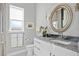 Bathroom vanity featuring a decorative mirror, granite countertop and soft, natural lighting at 3415 Tripoli Blvd, Punta Gorda, FL 33950
