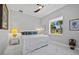 Bright bedroom featuring a bed with white bedding, a ceiling fan, and a large window overlooking lush outdoor greenery at 3415 Tripoli Blvd, Punta Gorda, FL 33950