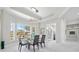 Spacious dining area with a glass table, modern lighting, and large windows overlooking the landscaped front yard at 3415 Tripoli Blvd, Punta Gorda, FL 33950