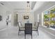 Elegant dining room featuring a glass table, modern chandelier, and view of the lush outdoor scenery at 3415 Tripoli Blvd, Punta Gorda, FL 33950