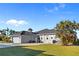 Rear view of a well-maintained single-story home with a two-car garage and brick paved patio at 3415 Tripoli Blvd, Punta Gorda, FL 33950