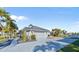Attached two-car garage and beautiful landscaping enhance this gray single-story home's curb appeal at 3415 Tripoli Blvd, Punta Gorda, FL 33950