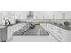 Modern kitchen boasts a large island with gray countertop and ample storage in the sleek white cabinetry at 3415 Tripoli Blvd, Punta Gorda, FL 33950