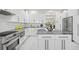 Well-lit kitchen featuring white cabinets, gray countertops, stainless steel appliances, and ample counter space at 3415 Tripoli Blvd, Punta Gorda, FL 33950