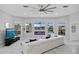 Spacious living room with a modern fireplace, large windows with waterfront views, and a ceiling fan at 3415 Tripoli Blvd, Punta Gorda, FL 33950
