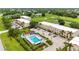 Aerial view of complex with a pool, parking and view of a golf course at 1186 Rio De Janeiro Ave # 106, Punta Gorda, FL 33983
