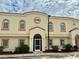 Office building with arched windows and neutral color palette under a partly cloudy sky at 1186 Rio De Janeiro Ave # 106, Punta Gorda, FL 33983