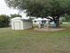 Spacious backyard features a patio, chairs, shed, and mature trees for shade at 1247 Petronia St, North Port, FL 34286