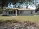 Expansive backyard with lush lawn, screened porch, and a view of the home's exterior at 1247 Petronia St, North Port, FL 34286