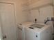 Laundry room with modern washer and dryer, storage, and bright lighting at 1247 Petronia St, North Port, FL 34286