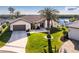 Stunning waterfront home featuring lush landscaping, a paver driveway, and a grand entrance with a magnificent palm tree at 1339 Casey Key Dr, Punta Gorda, FL 33950