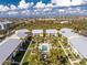 Aerial view of condo community featuring a swimming pool and lush landscaping against a blue sky backdrop at 2000 Bal Harbor Blvd # 1-111, Punta Gorda, FL 33950