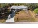 Aerial view of home with gray roof, a spacious yard, and a long driveway at 2325 Hanford Ln, North Port, FL 34288