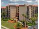 Condo community exterior view with mature landscaping, signage, and a well-maintained entrance at 3006 Caring Way # 409, Port Charlotte, FL 33952