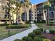 Beautiful multi-story condo building with tropical landscaping and palm trees along the walkway at 3006 Caring Way # 409, Port Charlotte, FL 33952