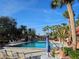 Sparkling community pool surrounded by lounge seating and lush landscaping on a clear day at 3006 Caring Way # 409, Port Charlotte, FL 33952