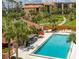Aerial view of community pool with palm trees, lounge seating, and manicured lawns surrounding the condo complex at 3006 Caring Way # 409, Port Charlotte, FL 33952