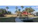 Picturesque community walkway lined with palm trees and manicured landscaping leading to a gated building at 3006 Caring Way # 409, Port Charlotte, FL 33952