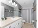 Neutral-toned bathroom featuring a wide mirror, vanity lighting, and coordinating shower curtain at 3264 Garbett Ter, North Port, FL 34288