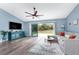 Bright living room with wood flooring, a ceiling fan, and sliding doors to the backyard at 3264 Garbett Ter, North Port, FL 34288