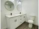 Bathroom features a double sink vanity, white cabinets, black hardware, and round mirrors at 4128 Durant St, Port Charlotte, FL 33948