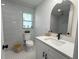 Updated bathroom features an arched mirror, white vanity, a tiled floor, and modern finishes at 4128 Durant St, Port Charlotte, FL 33948