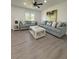 Bright living room featuring two couches with throw pillows, a glass top coffee table, and wood-look floors at 4128 Durant St, Port Charlotte, FL 33948
