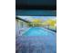 Beautiful in-ground pool with a screened-in enclosure, ladder access, and a view of the backyard at 4128 Durant St, Port Charlotte, FL 33948