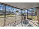 Inviting screened-in patio with outdoor seating, grill, and a peaceful view of trees and sky at 4175 Horseshoe Ave, North Port, FL 34286