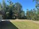The home's backyard is cleared and ready, framed by a variety of trees and tropical foliage at 432 Olivia Rd, Venice, FL 34293