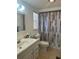 Bathroom featuring a well-lit vanity, commode, tile flooring, and a shower/tub with geometric curtain at 432 Olivia Rd, Venice, FL 34293