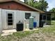 The back of the house features utility hookups, a door, window, and easy access to the screened patio at 432 Olivia Rd, Venice, FL 34293