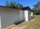 Exterior view of the home's side, featuring a yard with AC unit and tanks on the exterior at 432 Olivia Rd, Venice, FL 34293